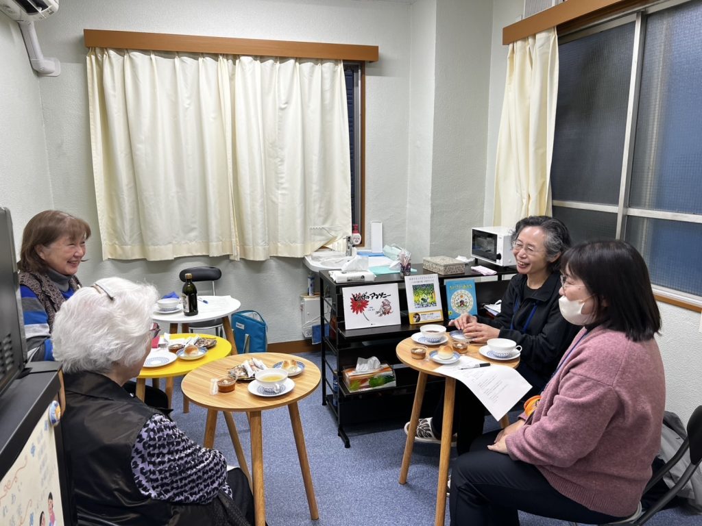 ふれあいカフェの写真。お茶とお菓子を囲んで4人の女性が楽しそうに語り合っている。